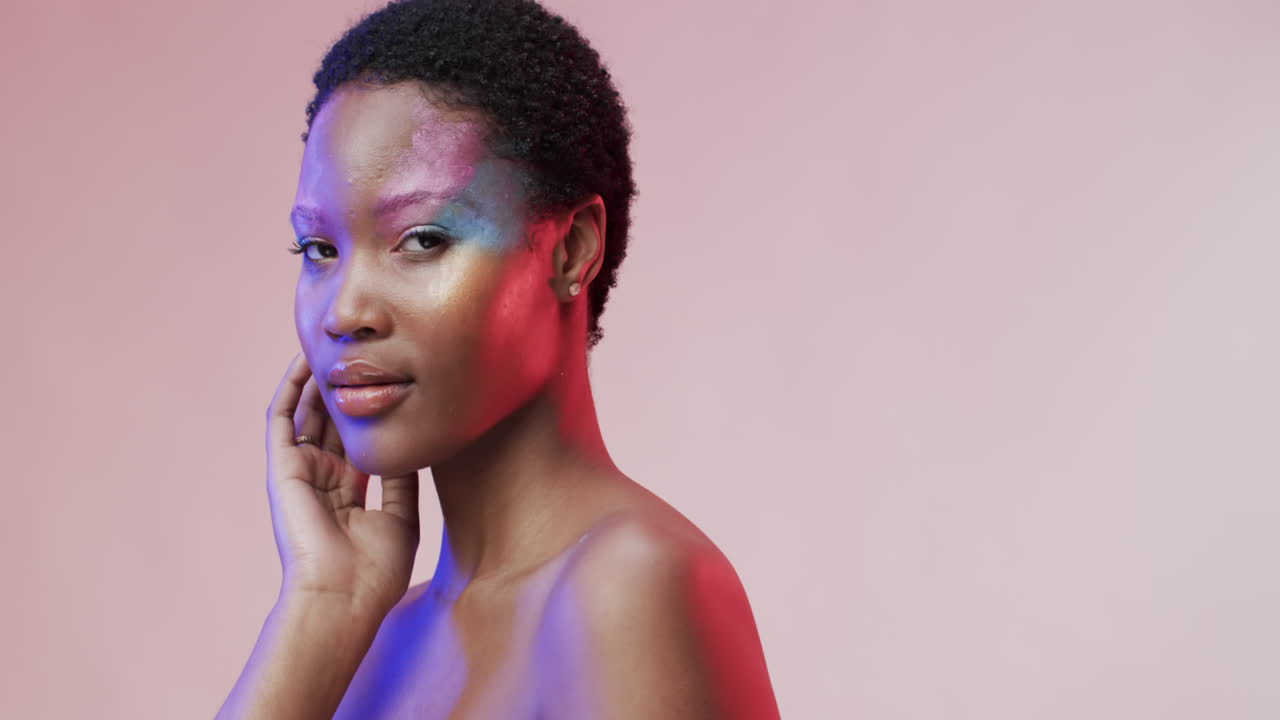 mujer afroamericana con cabello oscuro corto en luz azul y rosa con espacio de copia, cámara lenta