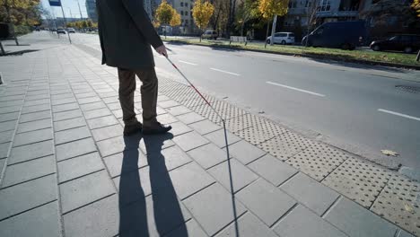 hombre ciego esperando el autobús en una estación de autobuses