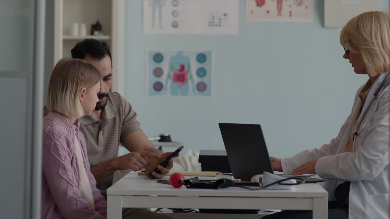 Doctor consulting with a father and daughter in a clinic
