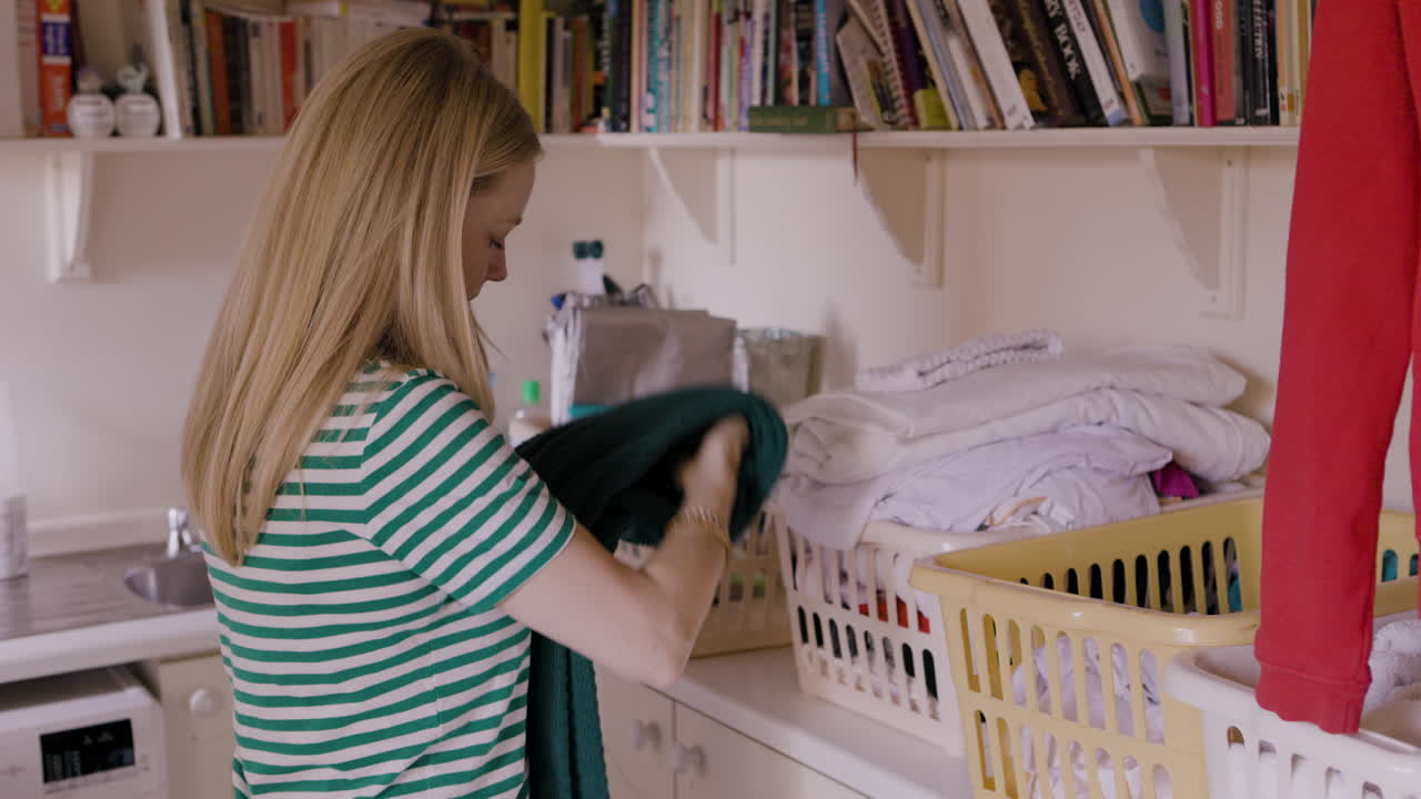 Woman folding laundry indoors