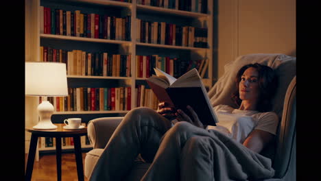 woman reading in a cozy home library at night
