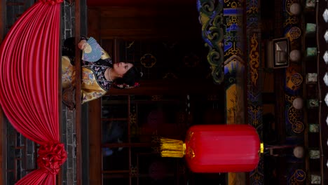 beautiful qing dynasty girl poses on decorated chinese balcony with hand fan in pingyao