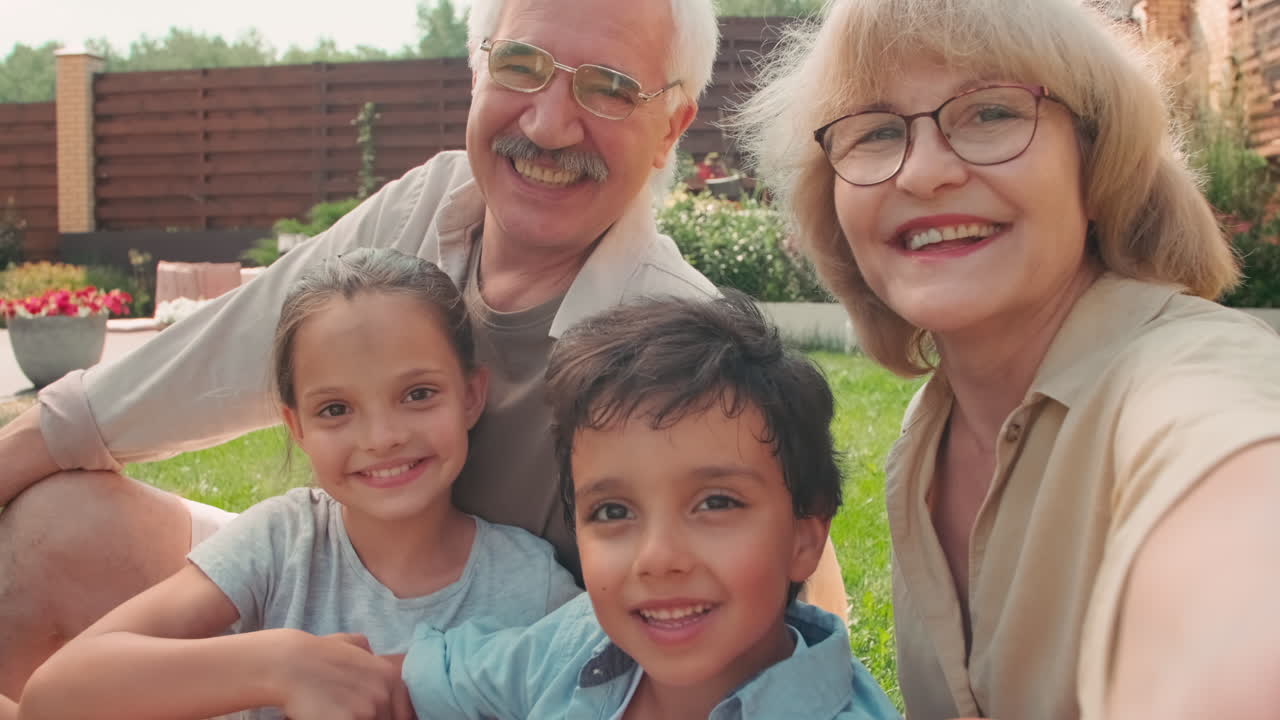 Senior Couple With Grandchildren Taking Selfie