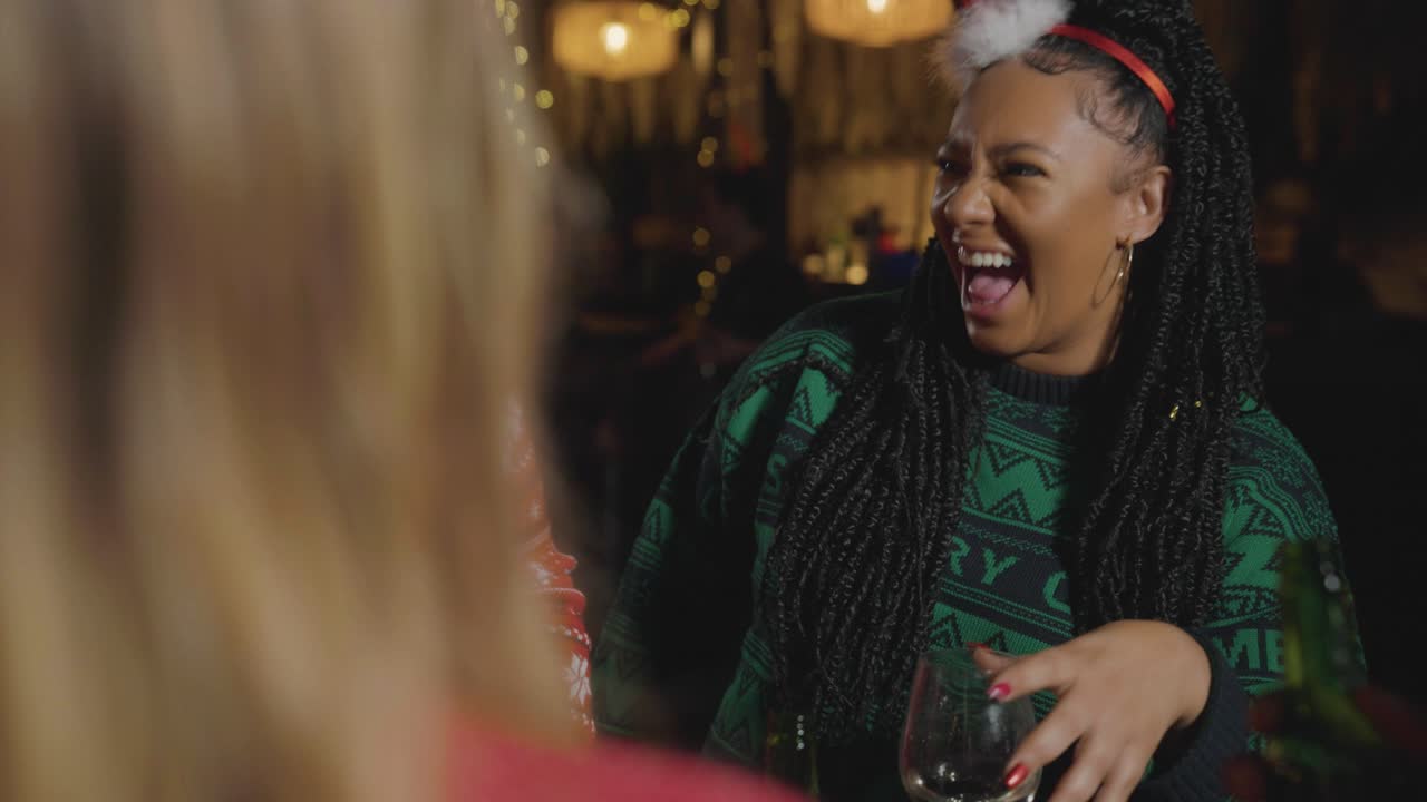 tiro de seguimiento alrededor de un pequeño grupo de amigos celebrando la navidad en un bar