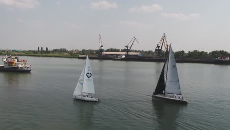 sailing race on river with industrial background