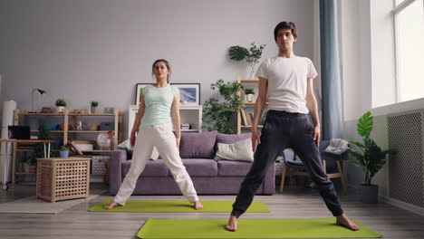 pareja practicando yoga en casa