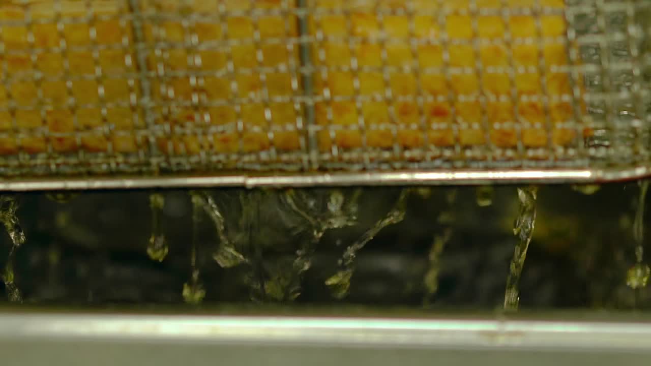 Close up slow motion Cooking fried Japanese rolls Hot oil drains from grate