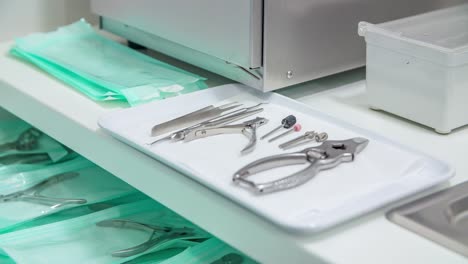 pedicure assistant places special nail drill nozzle on tray with other manicure tools