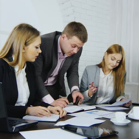 3 business colleagues discussing documents in office