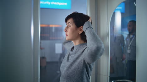 mujer en el puesto de control de seguridad del aeropuerto