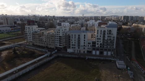 fort d'aubervilliers neighborhood with modern buildings and green spaces, france. aerial forward