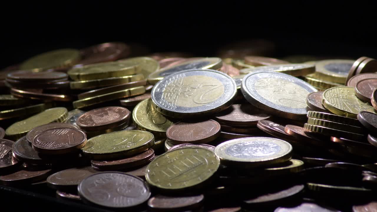 montaña con diferentes monedas de euro girando