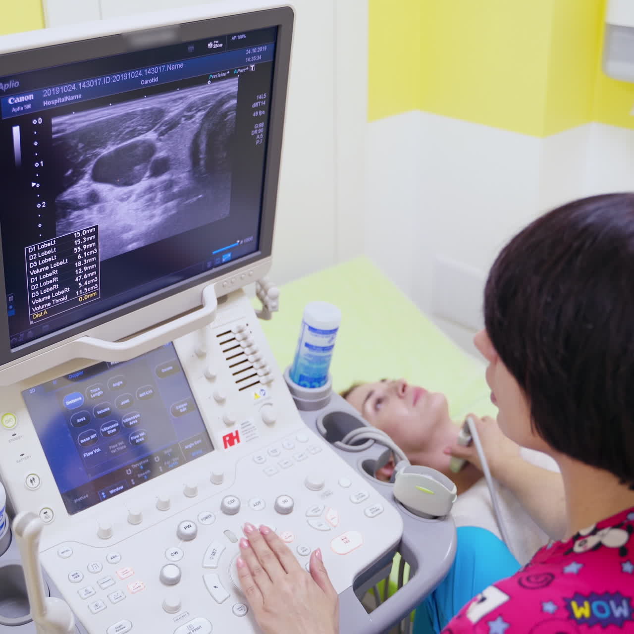Doctor makes ultrasound diagnostic. Woman specialist using ultrasound scanner in clinic. Doctor runs ultrasound sensor on neck and looking at screen.