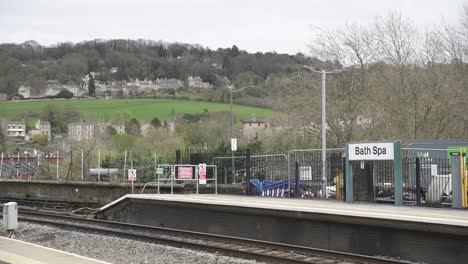 una vista de las vías del ferrocarril en bath, reino unido, con la hermosa arquitectura de la ciudad en la distancia, mostrando la mezcla de transporte tradicional y entorno histórico.