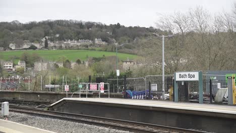 a view of the railroad tracks in bath, uk, with the city’s beautiful architecture in the distance, showcasing the blend of traditional transport and historic surroundings.