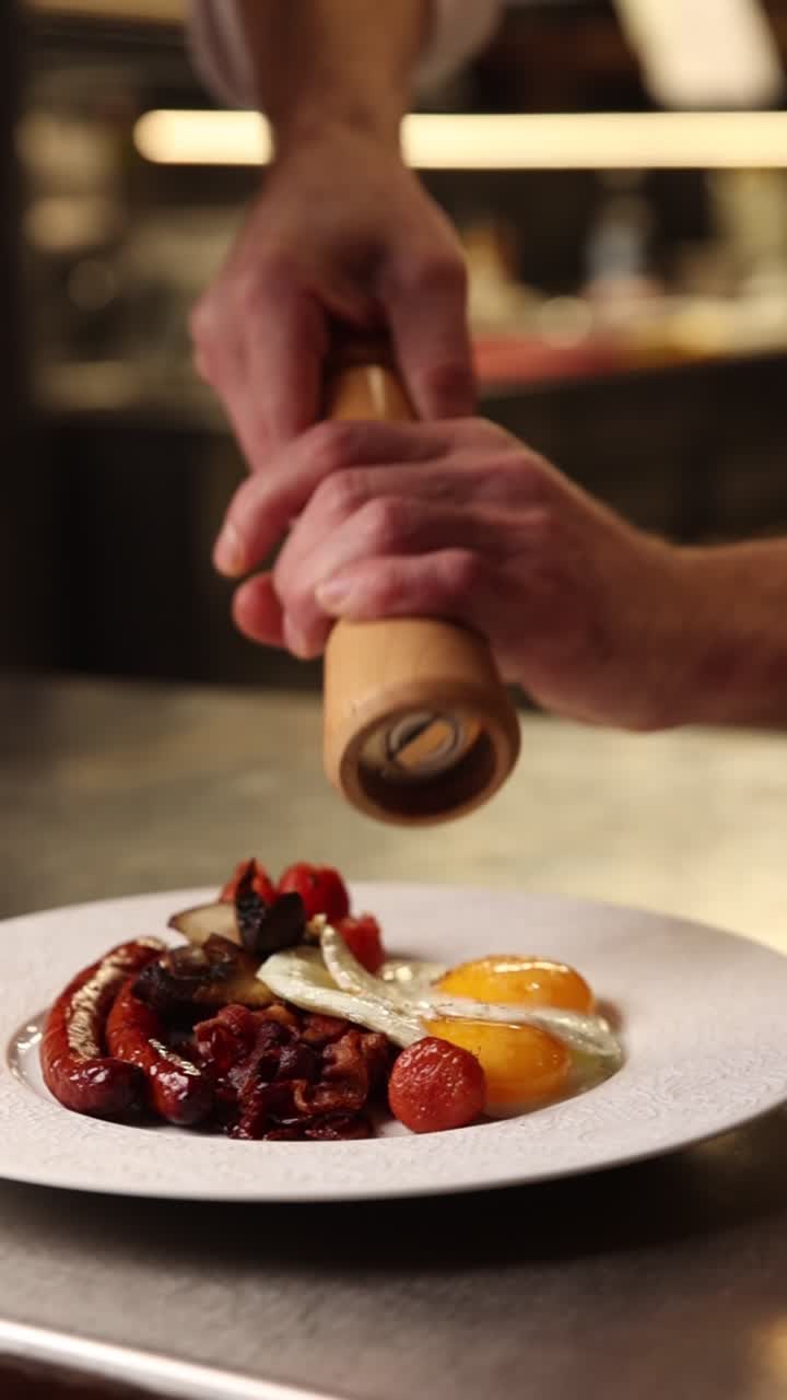 Chef che condisce un delizioso piatto per la colazione con un macinapepe