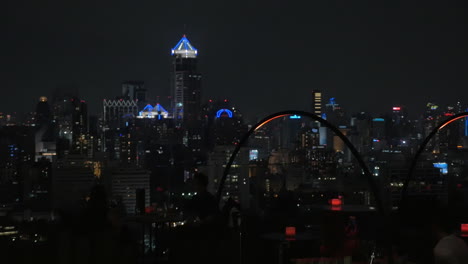 Night-cityscape-and-people-in-cafe-on-the-roof