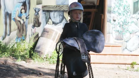 young girl with riding helmet and saddle