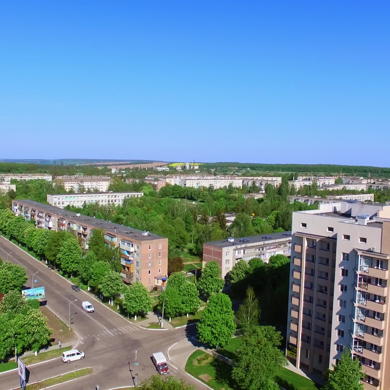 Quarters with multiple blocks of flats in the residential area. Long road and crossroads along green streets