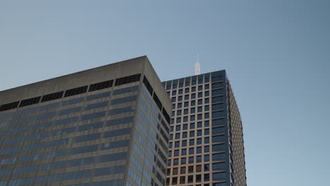 two modern sydney office buildings rising into a bright blue sky