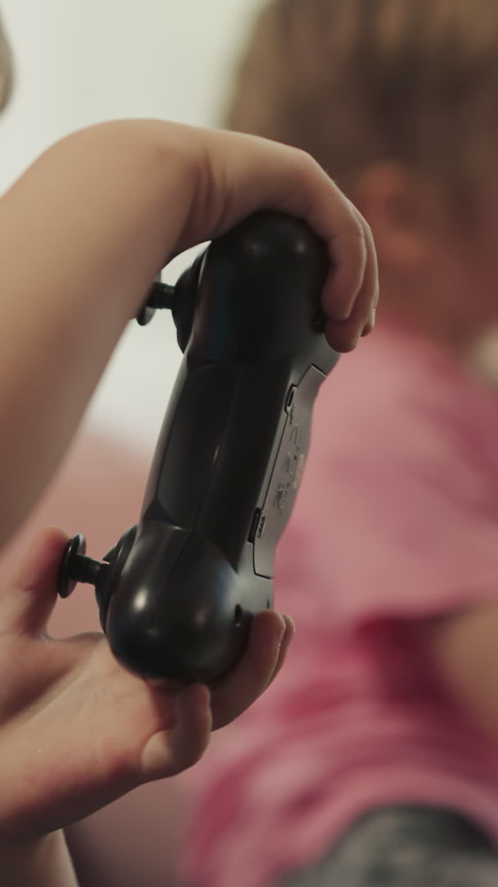 niños pequeños y preescolares centrados en consolas de control jugando videojuegos en un fondo borroso. niños adorables sentados en el sofá disfrutando de la competencia de primer plano