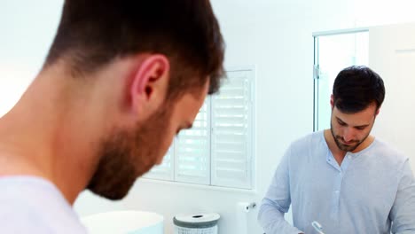 hombre cepillándose los dientes en el baño