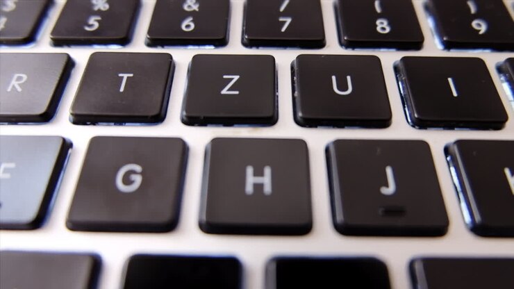 Close up of a black laptop keyboard in daylight