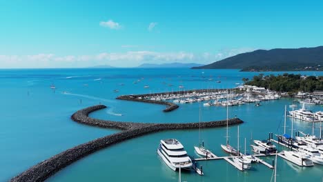 reverse reveal of coral sea marina as jet skis enter through the breakwater