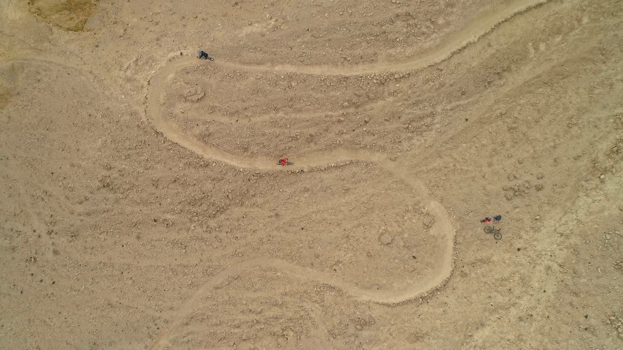 사막의 자전거 도로를 달리는 자전거 라이더 그룹의 최고 천사 공중 영상