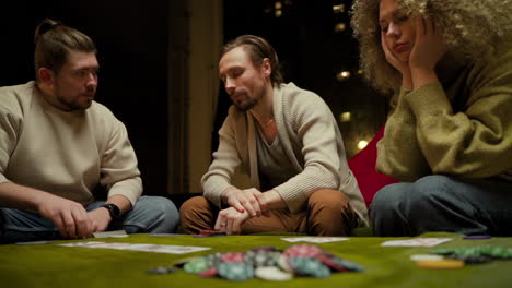 vista inferior del grupo de amigos jugando al póquer