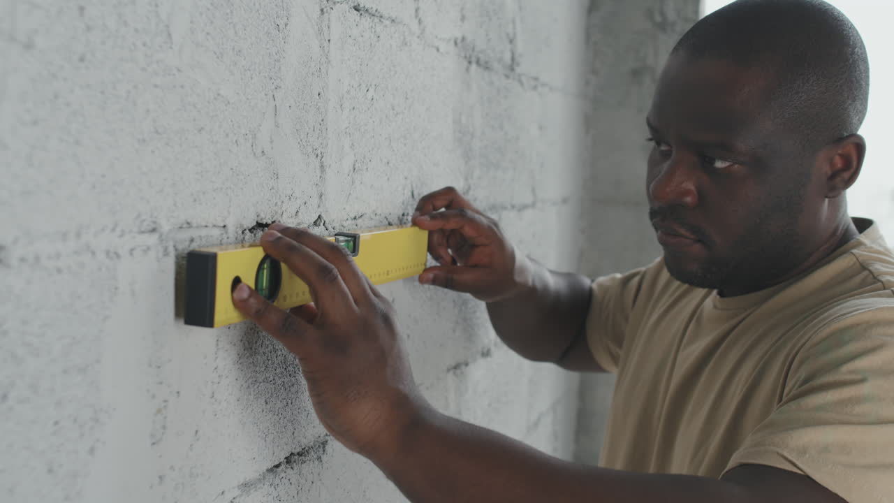 Man using a level on a wall