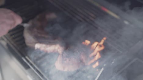 man cooking cooking meat on a smoky barbecue