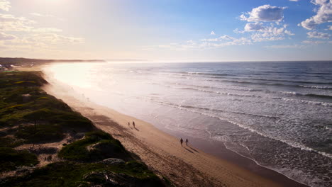 Los-Viajeros-Al-Amanecer-Pasean-Por-La-Playa-Con-Bandera-Azul-De-Lappiesbaai-En-Stilbaai