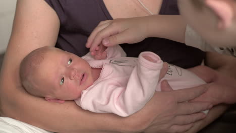 Grandma-with-newborn-and-brother-touching-baby-hands