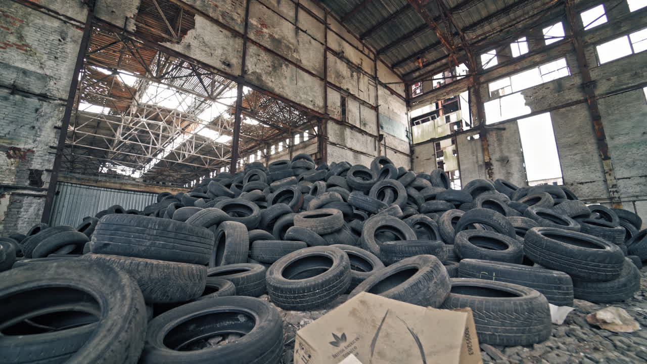 Old tires at a dump. Pile of old tires stacked in junkyard panned up from base to top