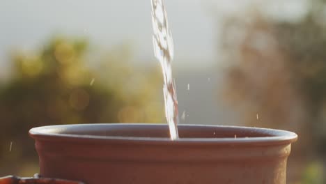 water pouring into a terracotta pot