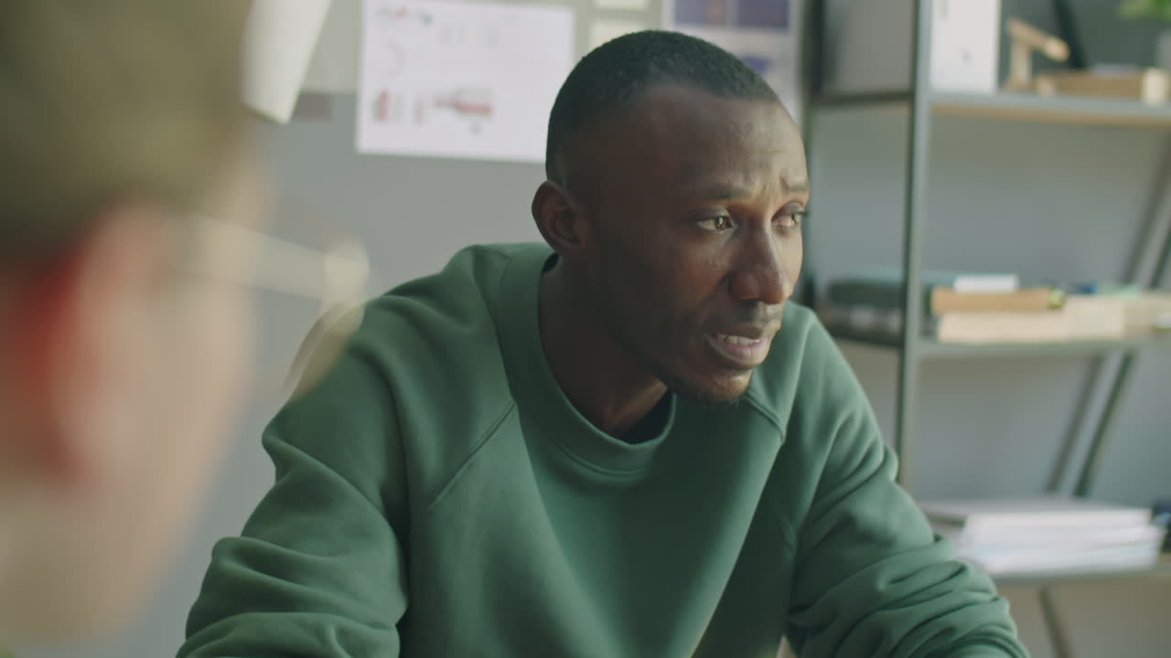Uomo di colore che parla con il team durante una riunione di lavoro