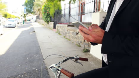 businessman using smartphone on his bike