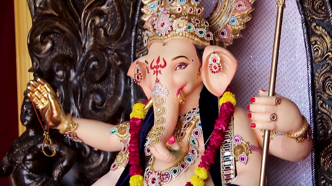 Statua di Ganesha seduta su un trono singhasan con gioielli d'oro durante il festival di Ganesh Chaturthi in India