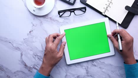 joven trabajando en una tableta digital con pantalla verde