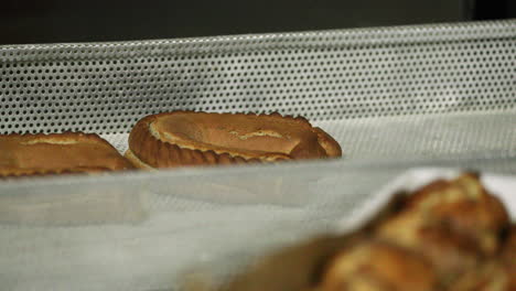 pan recién horneado en una rejilla de aluminio en la panadería - cerrar