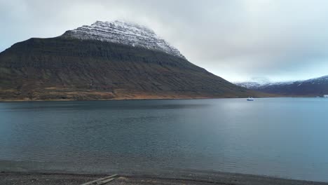 icelandic vacation home next to fjord with snowy mountain top aerial