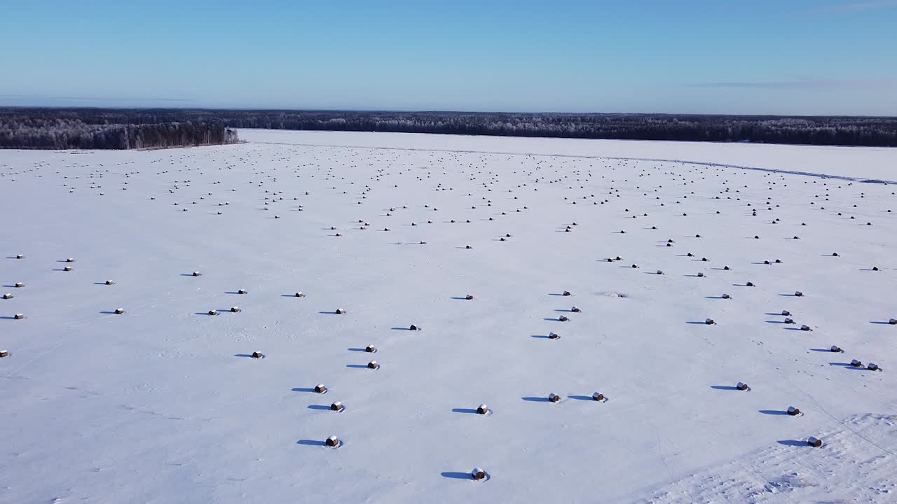 rollo de heno archivado cubierto de nieve vista aérea baja luz del sol largas sombras