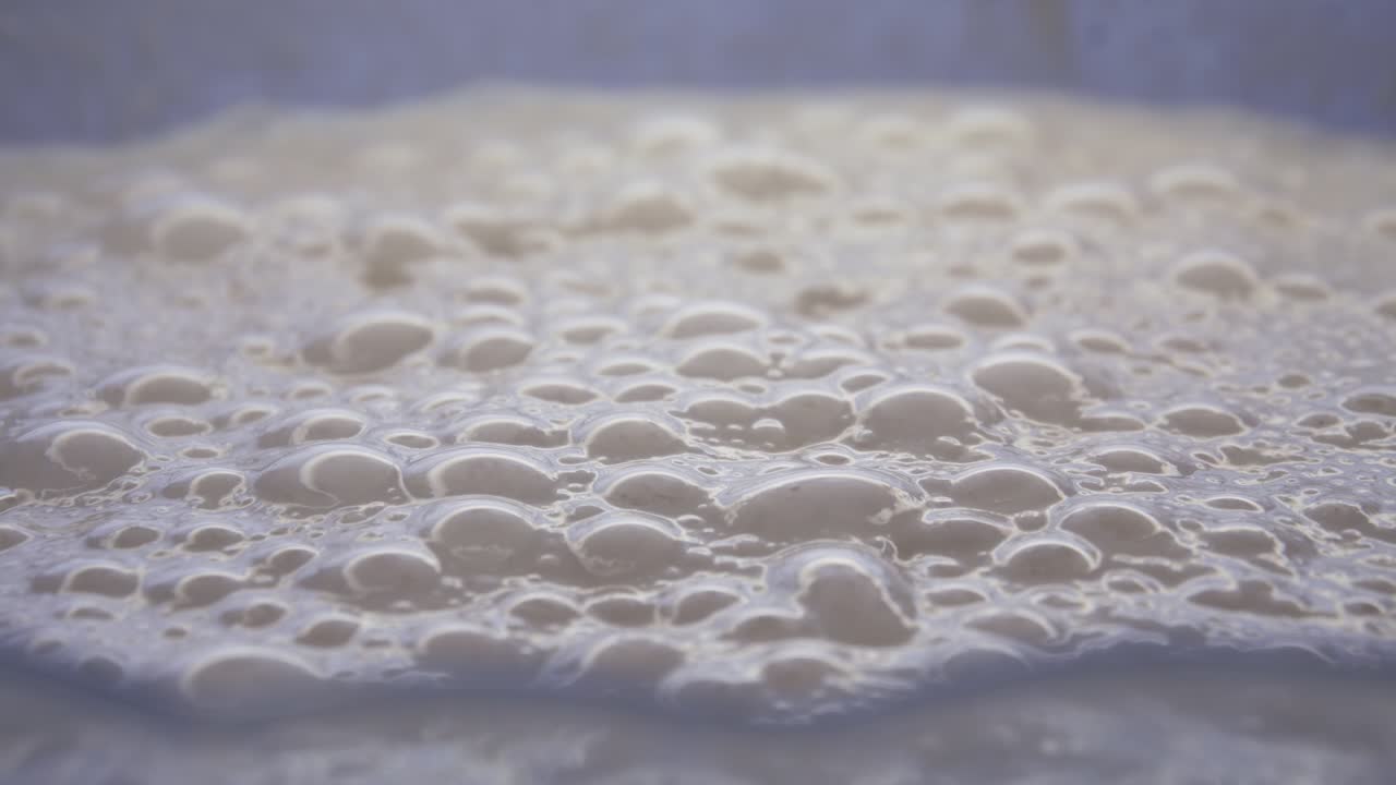 masa burbujeante de productos en un recipiente listo para hacer tortitas