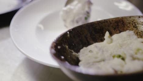 Chef-pouring-mashed-potatoes-into-dish