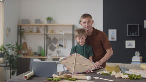 father and son making a kite together