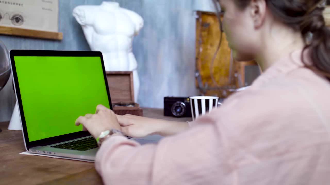 mujer trabajando en una computadora portátil en un estudio artístico