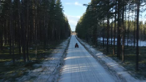 atv driving fast down a snowy road