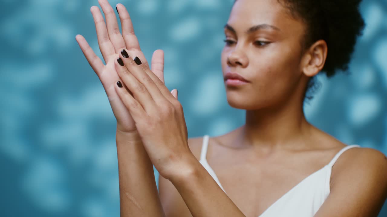 una mujer examinando sus manos.