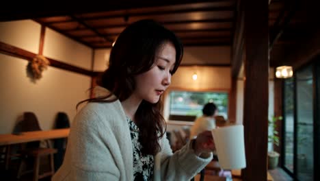 woman drinking coffee in a cozy japanese cafe